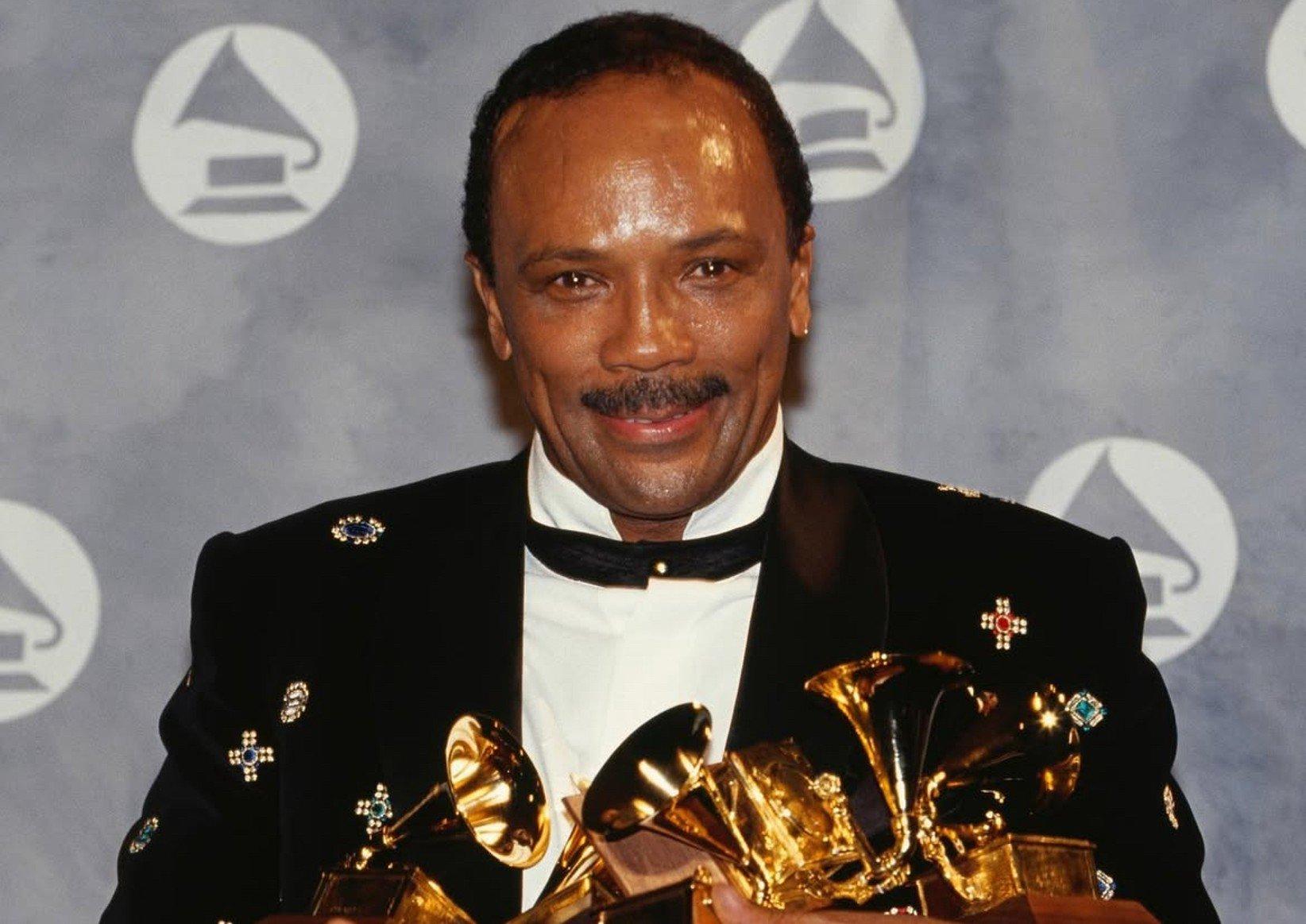 Quincy Jones holding GRAMMY awards in his arms